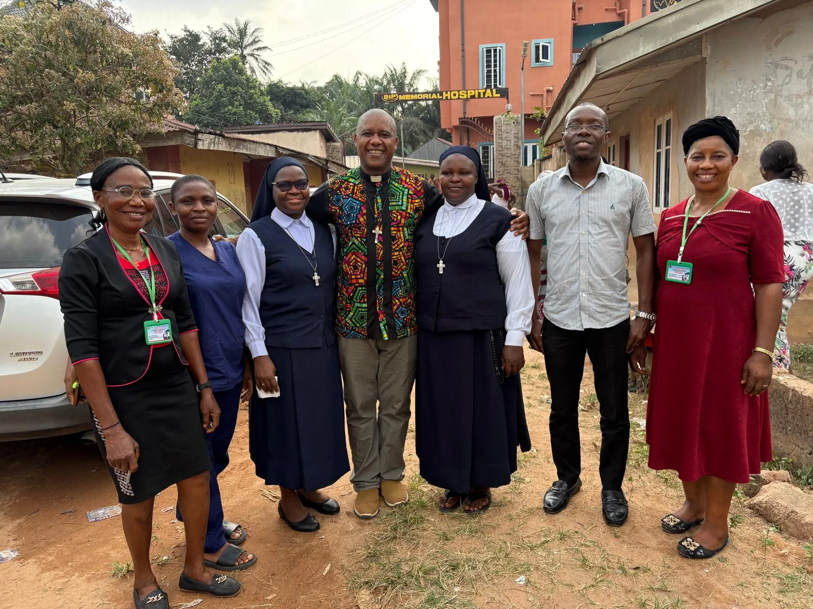Hospital staff and visitors standing outside the hospital