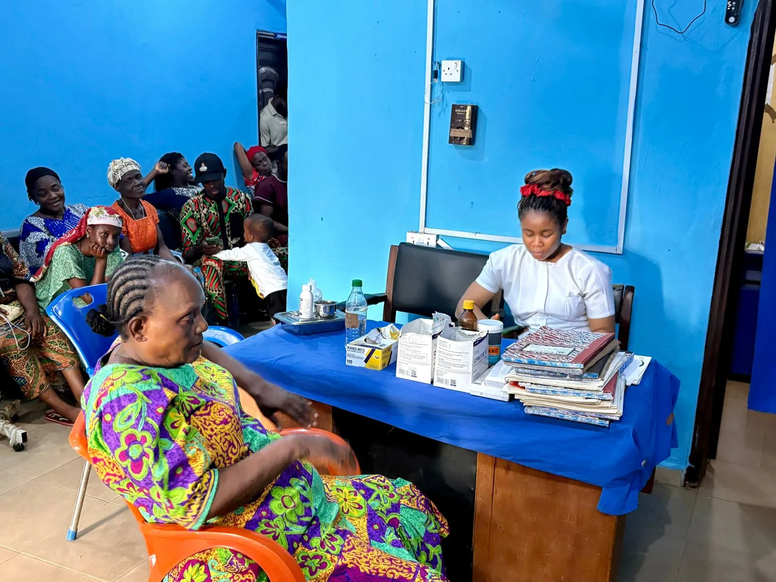 A nurse preparing medicines and vaccines at a clinic table